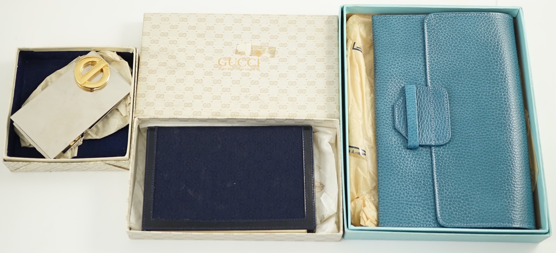 A Gucci blue leather address book, a Smythson leather travel wallet and a Christian Dior desk clip, all boxed.